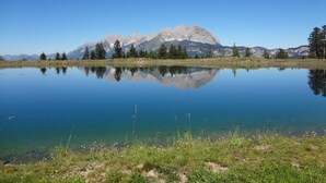 A calm lake with clear reflections of mountains and trees. - Franglhof Hohe Salve (Kirchberg in Tirol)