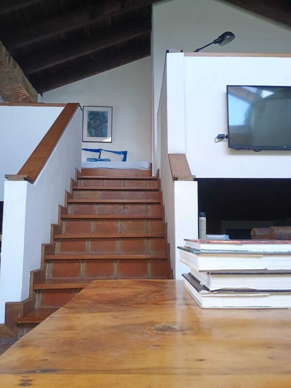 A staircase leading to a living area with a flat-screen TV mounted on the wall.