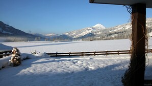 A snow-covered landscape with a wooden fence and a building's corner. - Franglhof Fleckalm in Kirchberg (Kirchberg in Tirol)