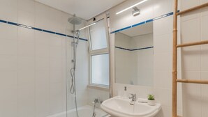 A bathroom with a bathtub, a sink, a mirror, and a shower. - Funchal City Nest in Funchal (Funchal)