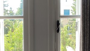 A room with two windows, a door, and a power outlet on the wall. - Yasmine Hammamet | Appartement calm and elegant (Yasmine Hammamet)