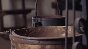 A rustic kitchen with a large metal pot and a smaller pot on a stove. - A Casa da Memoria - House-museum to live the experience of going back 100 years. (Aldea de Xullán)