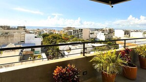 Un balcón con vista a un paisaje urbano, con edificios y cielo despejado.