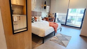 Un dormitorio moderno con cama, mesita de noche y vistas al balcón exterior.