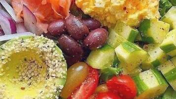 Uma saladeira com diversos vegetais e proteínas.
