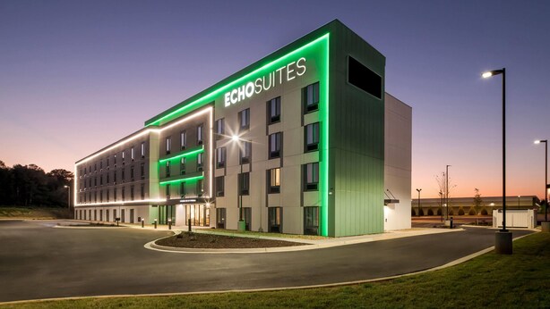 A modern hotel with a prominent "Echosuites" sign, featuring a clean, rectangular design with multiple floors and a well-lit entrance. - Echo Suites Extended Stay by Wyndham Atlanta-Conyers (Conyers)