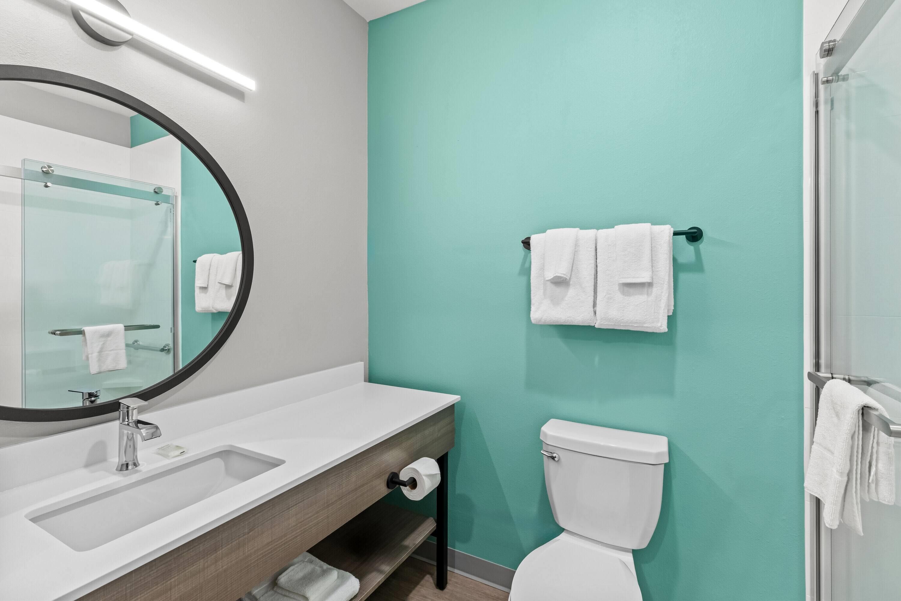A bathroom with a white sink, a toilet, and a glass shower enclosure.