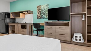 A hotel room with a bed, a kitchenette, a TV, and a wardrobe. - Echo Suites Extended Stay by Wyndham Atlanta-Conyers (Conyers)