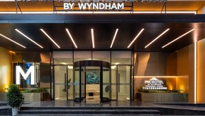 L’extérieur du Microtel by Wyndham Chengdu Jinniu Hotel présente un design moderne, avec un grand panneau en forme de « M », une porte tournante et un espace de réception doté d’un écran numérique.