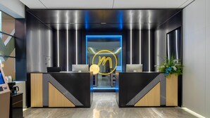 Un espace d’accueil moderne au design épuré, avec un logo bien visible et un comptoir d’accueil.