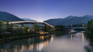 Ein Hotel mit modernem Design, einer Brücke und einem Fluss.