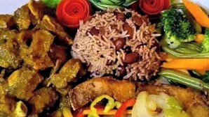 A plate of food with rice, beans, vegetables, and a fried item. - White Chase Hotel and Suites (Lagos)
