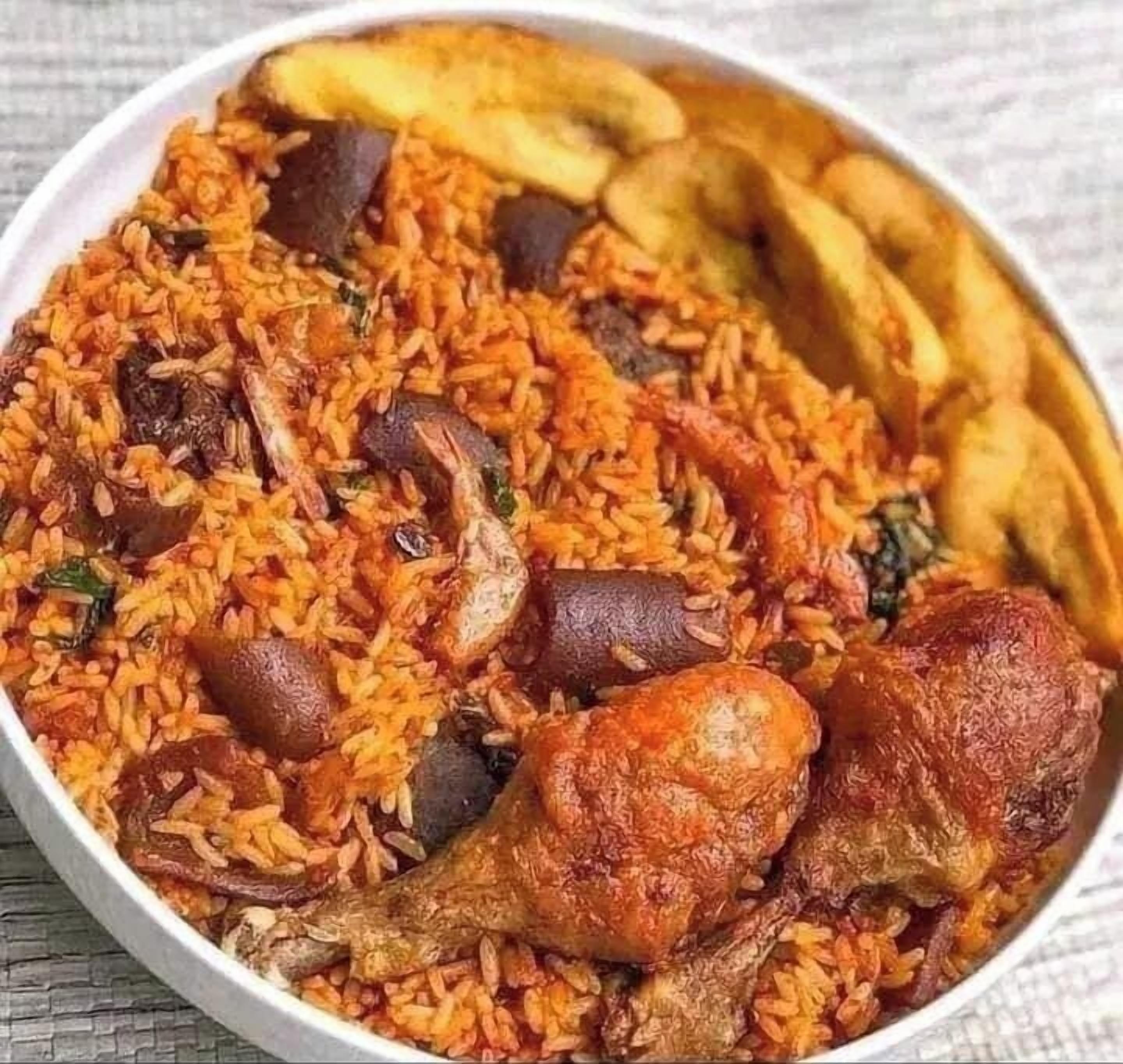 A bowl of rice with chicken and vegetables.