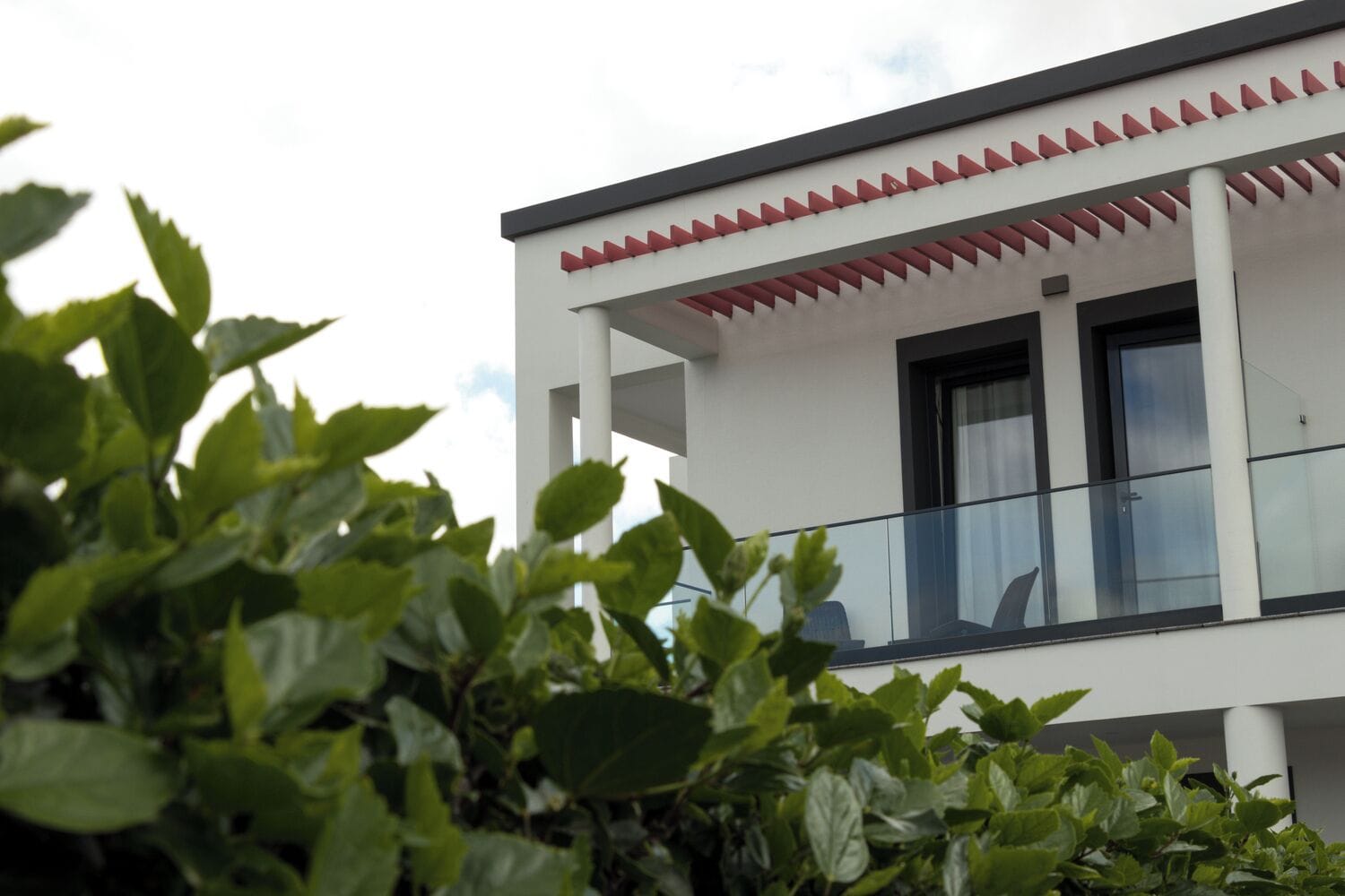 Um edifício moderno com varanda e fachada branca.