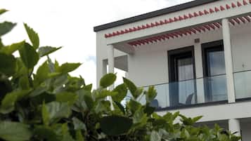 Um edifício moderno com varanda e fachada branca.