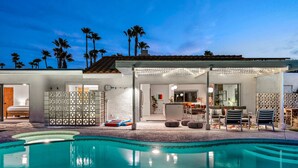 A poolside area with a covered seating area, a bar, and a pool. - Kaptur Palms (Palm Springs)
