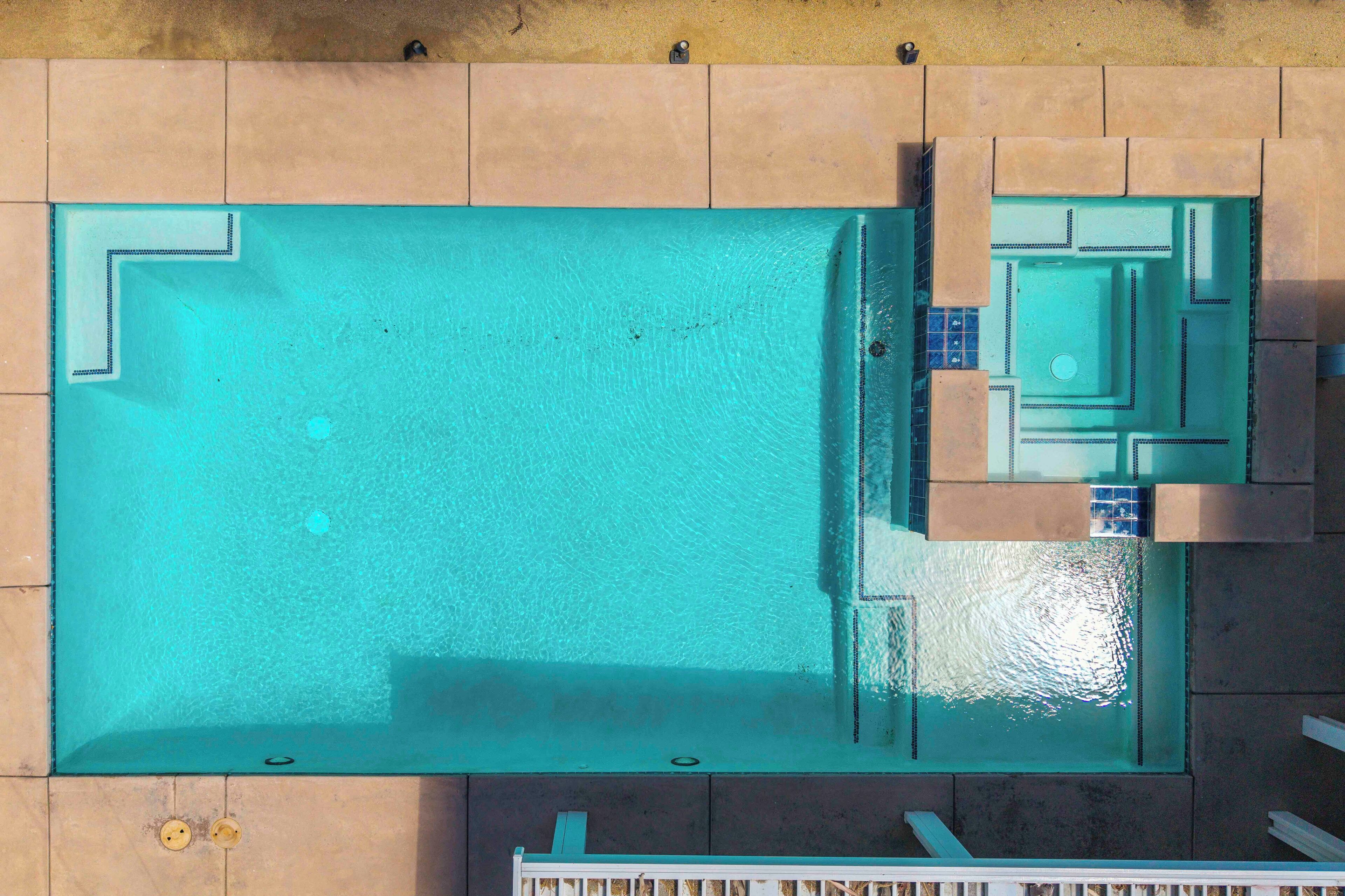 Vista aérea de una piscina rectangular con un borde de baldosas.