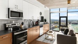 A modern kitchen with a large window, a view of the city, and a dining area with a view.