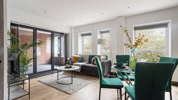 A modern living room with a sofa, chairs, a coffee table, and a dining area with a table and chairs.