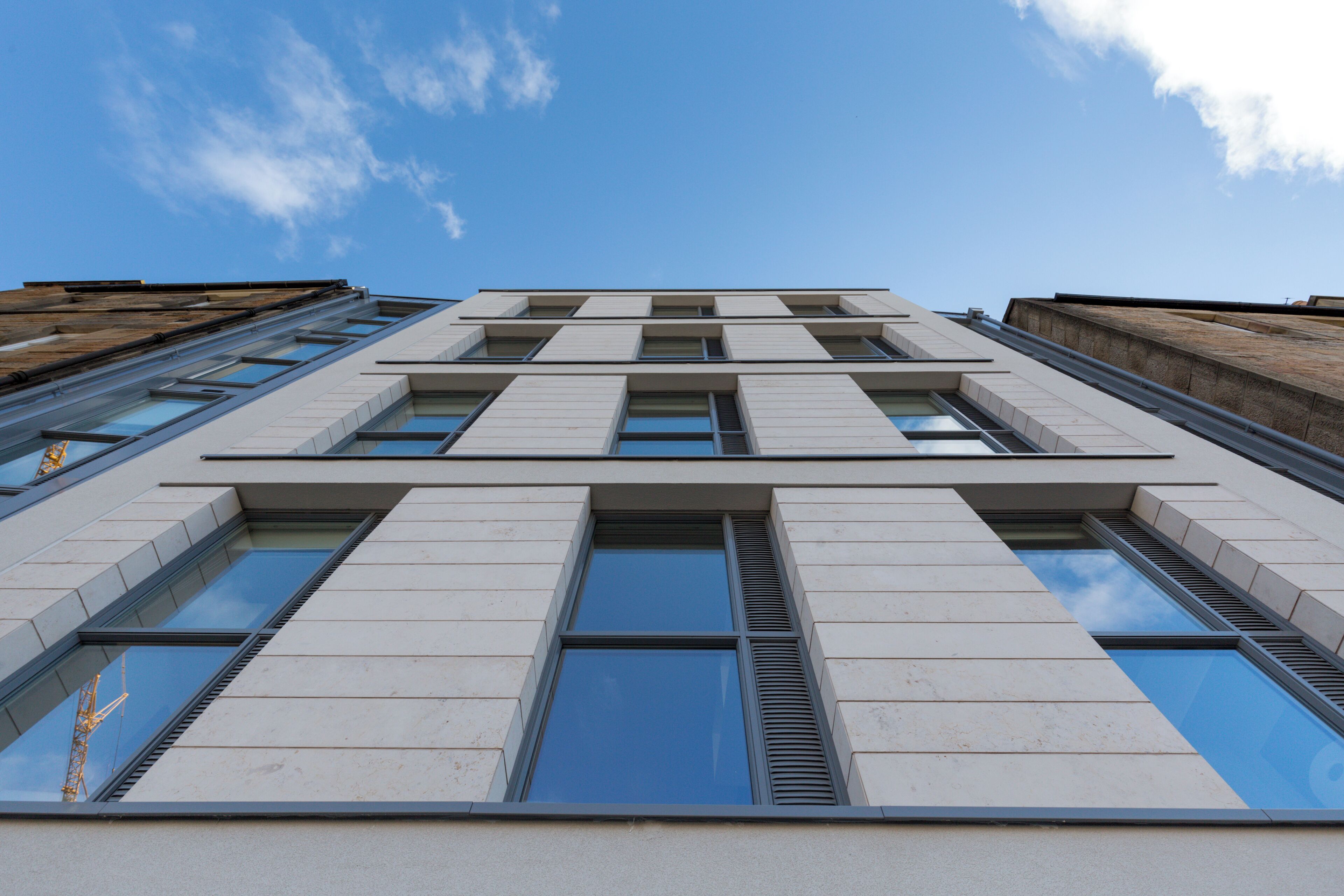 A modern building with a symmetrical facade, large windows, and a clear sky.