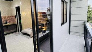 Une chambre moderne avec un lit, une petite table et une fenêtre.