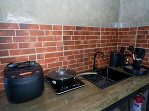 Een kookplaat, kookgerei, borden en bestek