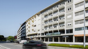 Un immeuble à plusieurs étages doté d’une architecture moderne, avec des balcons et de grandes fenêtres.