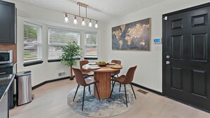 A dining area with a round table, chairs, a potted plant, and a modern light fixture. - Atlanta Vacation and Family Stay, Sleeps 10, King Beds, near the Atlanta Airport (Atlanta)
