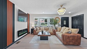 A modern living room with a sofa, coffee table, and fireplace. - Atlanta Vacation and Family Stay, Sleeps 10, King Beds, near the Atlanta Airport (Atlanta)