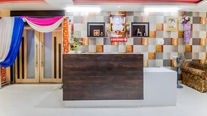 Ein Empfangsbereich mit Holzbüro, gerahmten Bildern an der Wand und einer Rezeption.