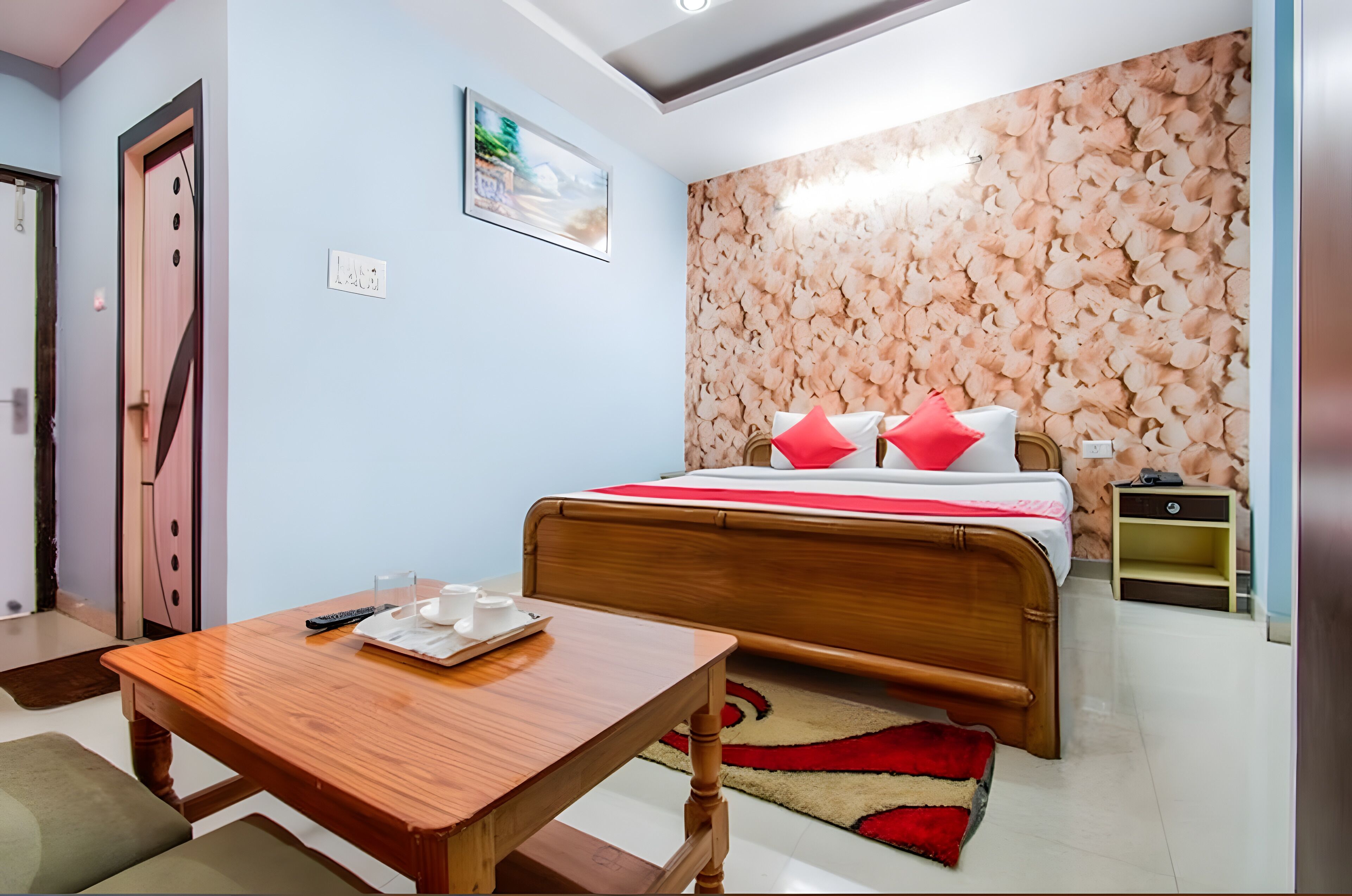 Un dormitorio con una cama de madera, una mesita de noche y una pared con estampado floral.