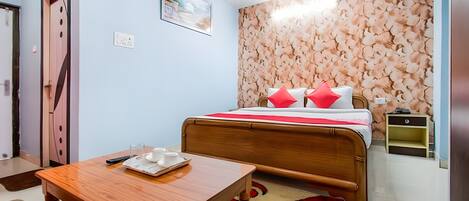 Un dormitorio con una cama de madera, una mesita de noche y una pared con estampado floral.