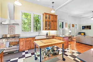 A kitchen with wooden cabinets, a central island, and a checkered floor.