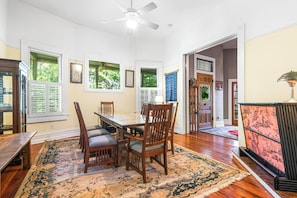 A dining area with a wooden table, chairs, and a patterned rug.
