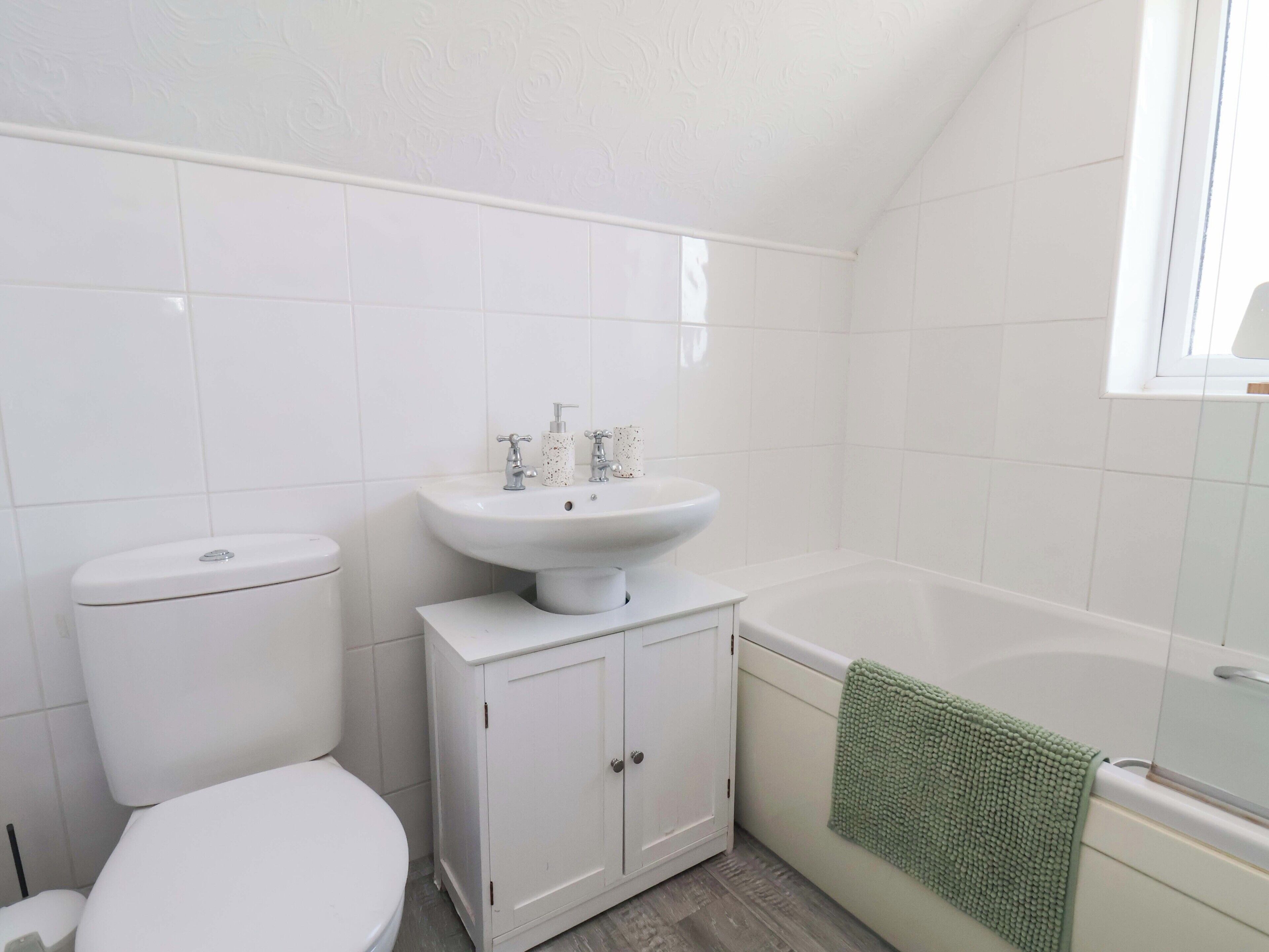 Ein Badezimmer mit Toilette, Waschbecken und Badewanne.