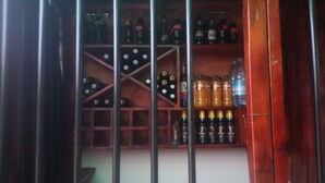 Una zona de bar con estantes llenos de botellas, incluyendo Guinness y otras bebidas alcohólicas.