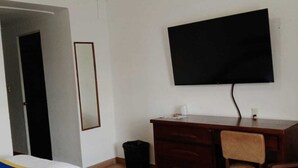 A hotel room with two beds, a desk, a chair, a television, and a trash bin. - HOTEL SIERRA GORDA (Ciudad Victoria)