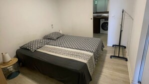 Une chambre à coucher avec un lit, un lave-linge et un radiateur.