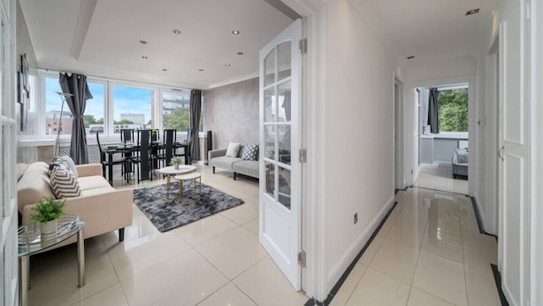 A modern living room with a sofa, coffee table, and dining area. - Stylish 2BR Flat | Oxford Street Locale (Greater London)