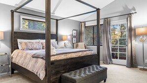 A four-poster canopy bed with a bench, bedside lamps, and a view of the outdoors. - 5bdr Stay w/ Fireplace, Game Room & Family-friendly Amenities Arrowhead Chalet by Avantstay (Lake Arrowhead)