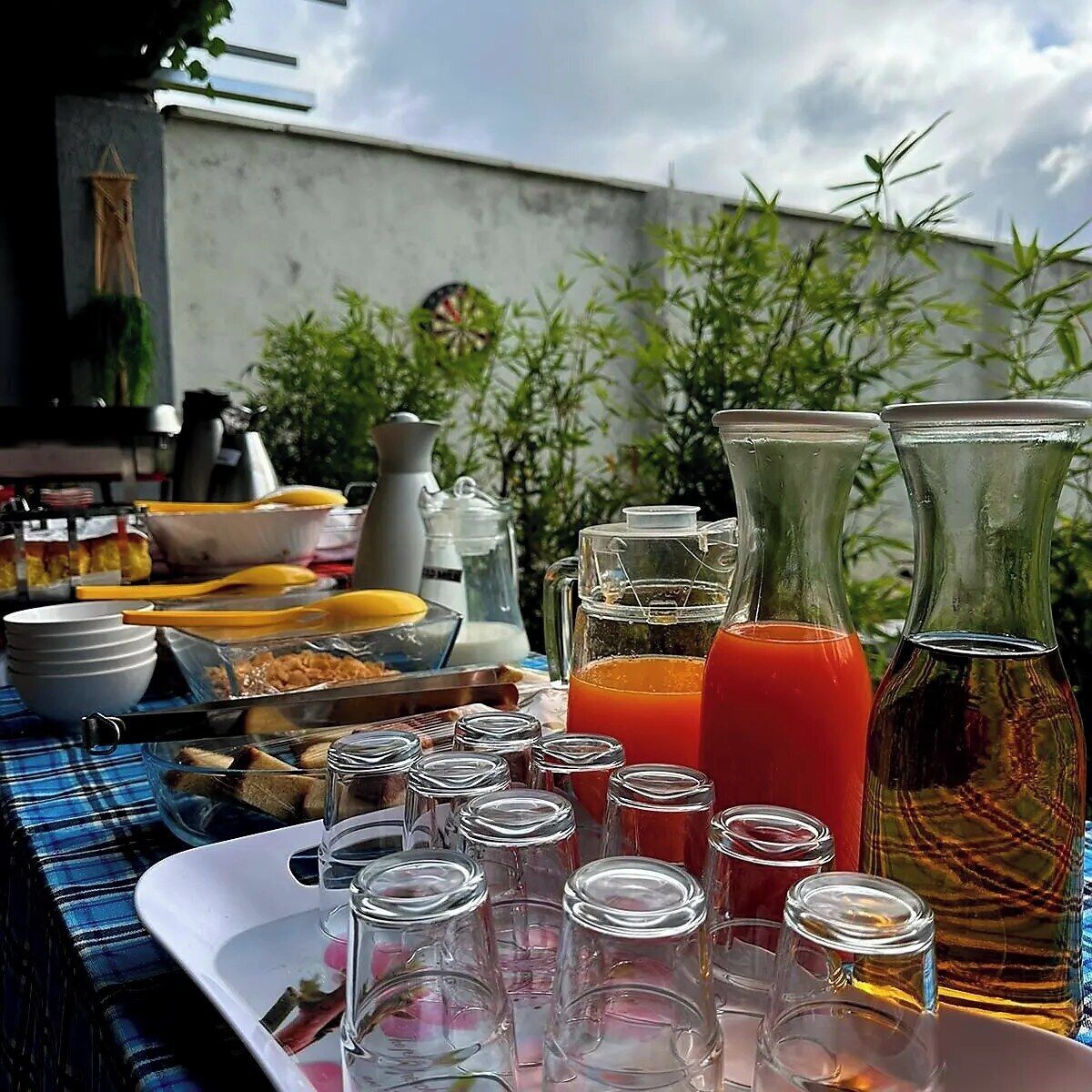 A breakfast setup with various food items, drinks, and utensils on a table.