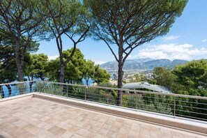 A balcony with a tiled floor and metal railing, overlooking a scenic view of trees and a distant cityscape. - Luxury Villa with pool, gym & garden in Sorrento (Priora)