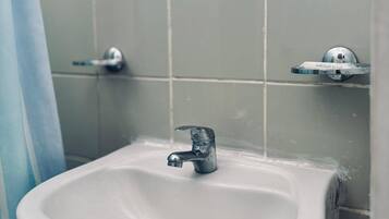 A bathroom with a white sink, a mirror, and a shower curtain.