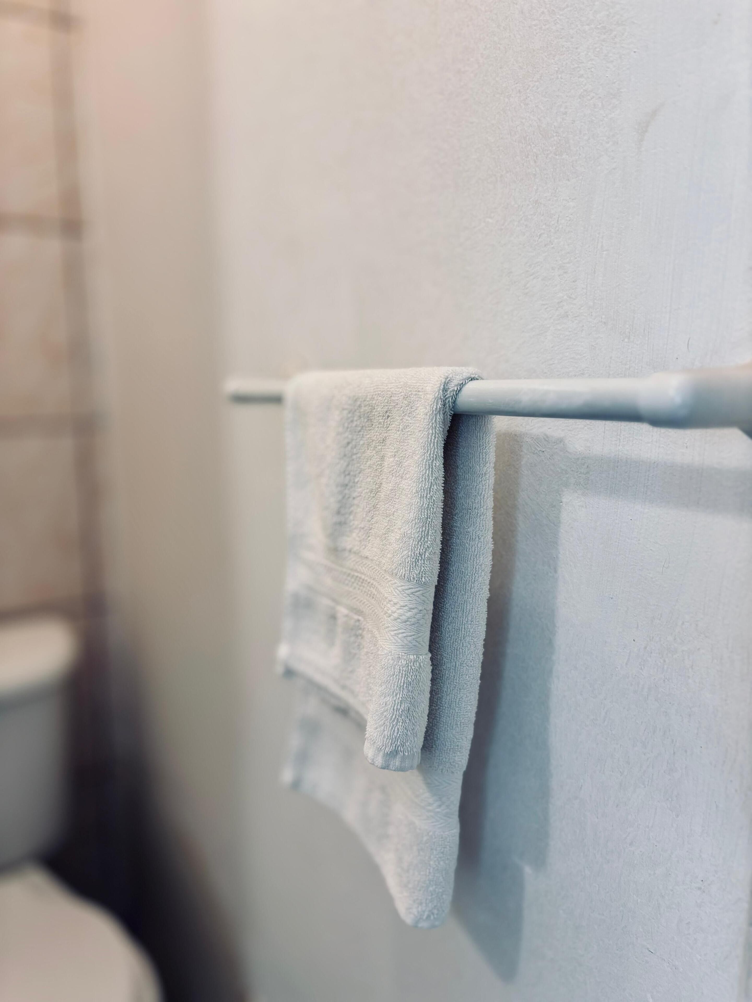 A bathroom with a white towel hanging on a metal towel rack.