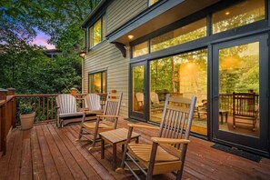 A wooden deck with Adirondack chairs and a glass door leading to a deck area. - Quiet Riverfront Retreat, 3 Decks, Lake/Kayaks (Jackson County)