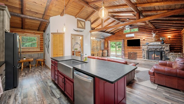 L’intérieur d’une cabane en rondins comprend une cuisine, un coin repas et un salon.