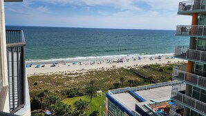 A beach view from a balcony with a clear sky, sandy beach, and ocean. - Our Newest Premium Ocean View Property - 2BR/2BA: Sleeps 8 - Top Amenities! (Myrtle Beach)
