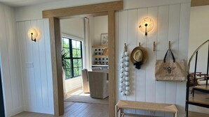 A room with a wooden bench, a wall-mounted hat rack, and a hanging light fixture. - Don Pedro Island: Canal w. dock and 5-Min to Beach (Englewood)