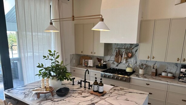A kitchen with marble countertops, a central island, a sink, and a stove. There are cabinets, a plant, and various kitchen utensils visible. - Don Pedro Island: Canal w. dock and 5-Min to Beach (Englewood)