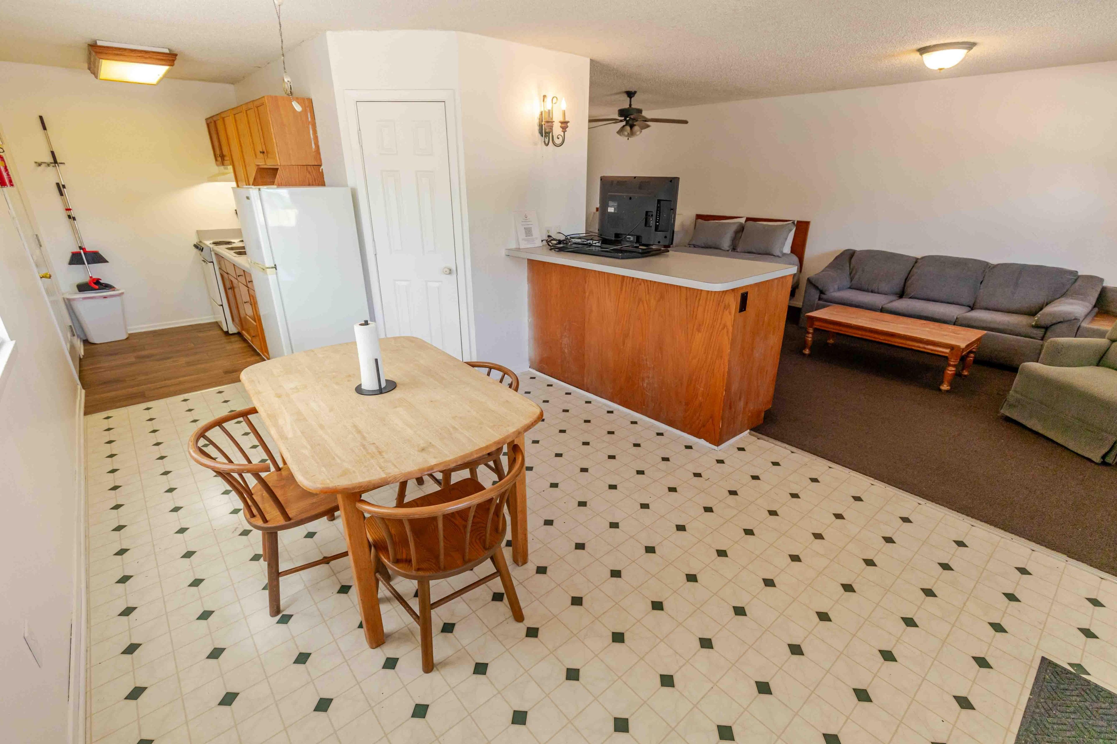 Un espace de vie compact comprenant un coin repas, une kitchenette et un coin salon.